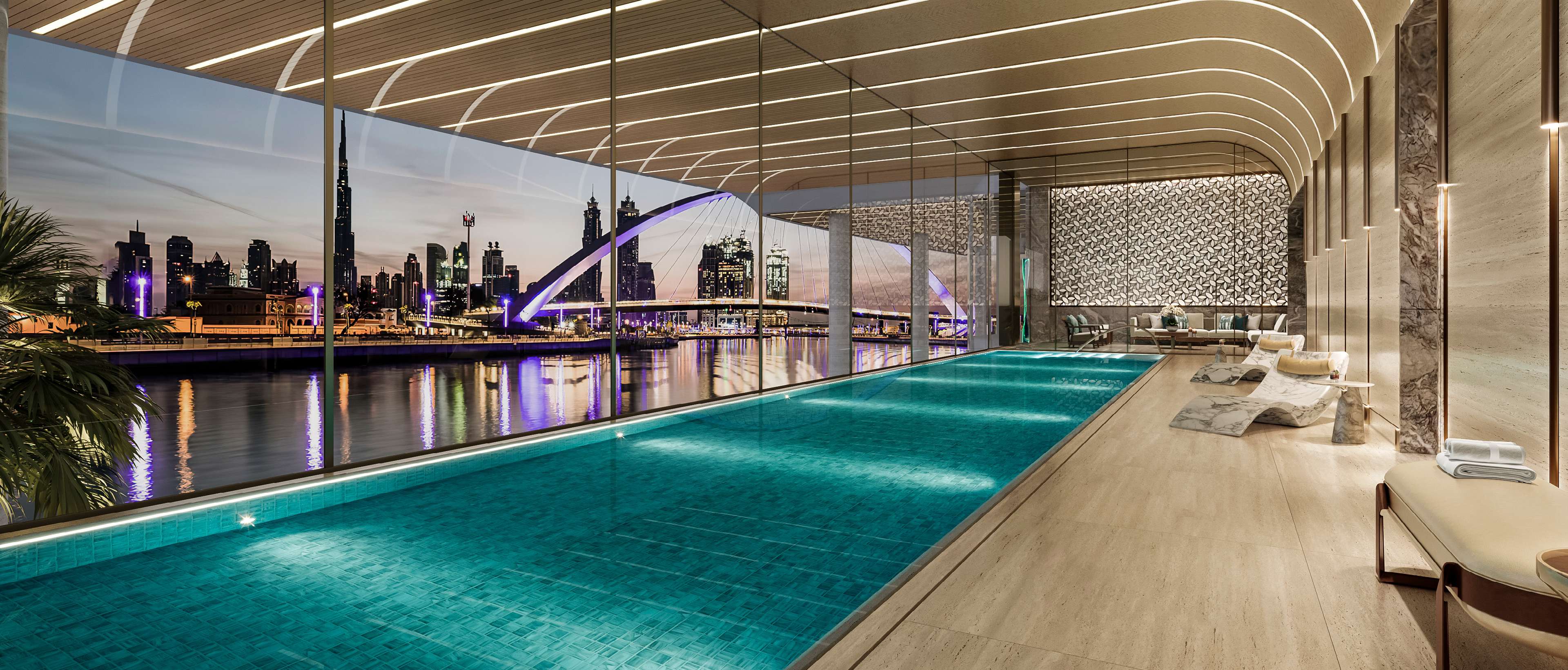 Indoor pool behind tall glass looking over the canal at dusk